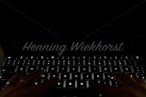 Dunkle Hände auf der Tastatur - ImageShop Online